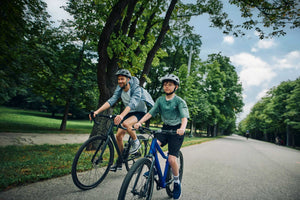 Boy cycling with his father on his Woom EXPLORE 6 magnetic blue bike.