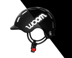 Side view of the Woom matt black kids helmet showing the reflective logo.