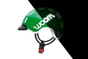 Side view of the Woom green kids helmet showing the reflective logo.