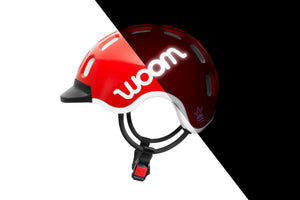 Side view of the Woom red kids helmet showing the reflective logo.