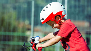 Young boy wearing MET YoYo White Red Flames glossy white and red kids helmet.